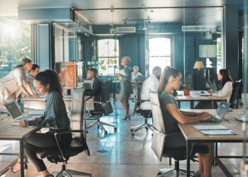 Corporate business people working in busy marketing office space, planning strategy in books and reading email on laptop at work. Businessman, businesswoman and workers at startup advertising company.