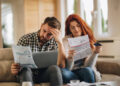 Worried couple feeling frustrated while have to pay their bills over Internet.