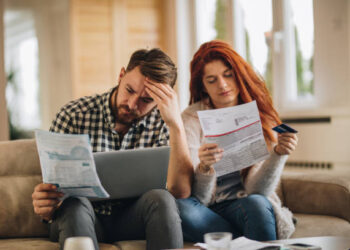 Worried couple feeling frustrated while have to pay their bills over Internet.