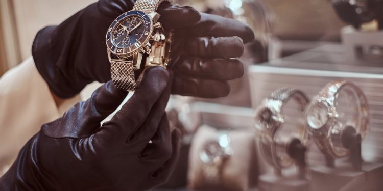 Close-up of the seller's hands in gloves shows the exclusive men's watch from the new collection