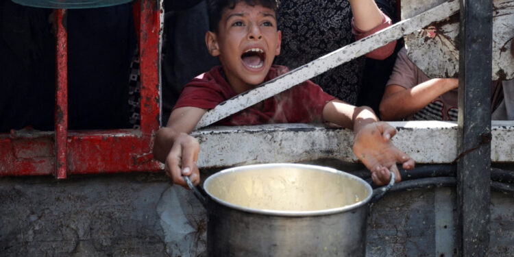 A Palestinian reacts as he waits to receive food from a charity kitchen, amid a hunger crisis, in Gaza City, July 28, 2025. REUTERS/Khamis Al-Rifi     TPX IMAGES OF THE DAY