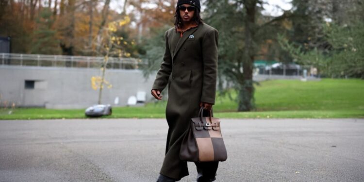 Kombëtarja Franceze mbërrin në hotel, duke evokuar Javën e Modës në Paris.