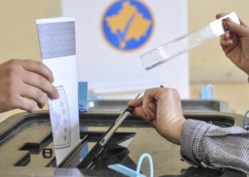 Prokuroria në Mitrovicë Pezullohet Numrimi i Fletëve të Votimit Pas Ankesave për Parregullsi
Mitrovicë, 11 nëntor 2025 – Prokuroria Themelore në Mitrovicë ka njoftuar se ka urdhëruar ndalimin përkohësisht të numërimit të fletëve të votimit në Qendrën Komunale të Numërimit. Kjo masë vjen si pasojë e raportimeve për parregullsi, duke përfshirë ndryshime në numrat serial të disa fletëve votuese, që kanë çuar në ndalimin e votimit nga komisionerët. Janë ngritur gjithashtu akuza për manipulim të mundshëm me fletë votime. Urdhri do të jetë në fuqi deri në marrjen e një përgjigjeje nga operatori që ka shtypur fletë votimet, për të sqaruar nëse kemi të bëjmë me gabime teknike apo me manipulime, pas së cilës do të merren masat e nevojshme.