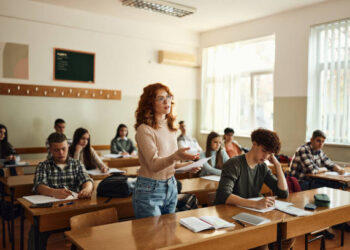 Teenage high school student talking during an oral exam in the classroom.