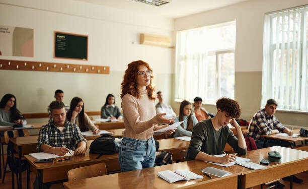 Teenage high school student talking during an oral exam in the classroom.