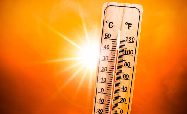 Background for a hot summer or heat wave, orange sky with with bright sun and thermometer