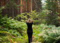Forest baths, restoration of strength and psyche, an adult woman walks along forest path among ferns